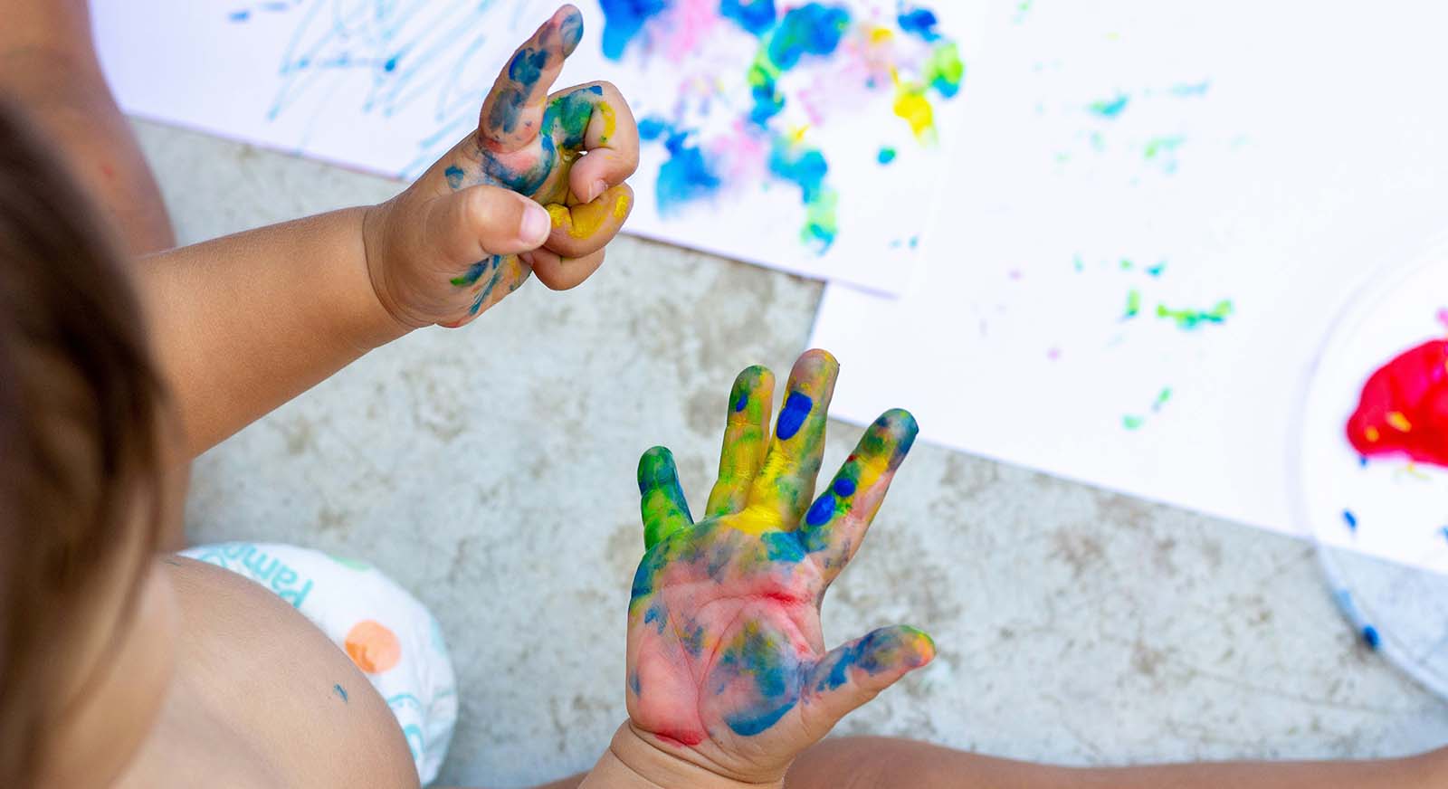handprints a toddler with paint on both hands