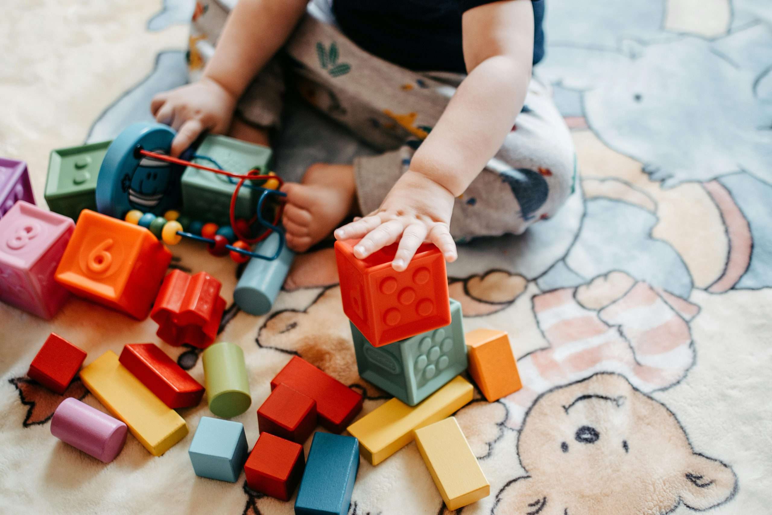 pexels-fotios-photos-5435599 a small child playing with blocks in a variety of shapes and colors