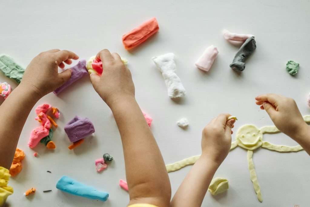 pexels-pavel-danilyuk-8422174 Small hands playing with colored pieces of clay