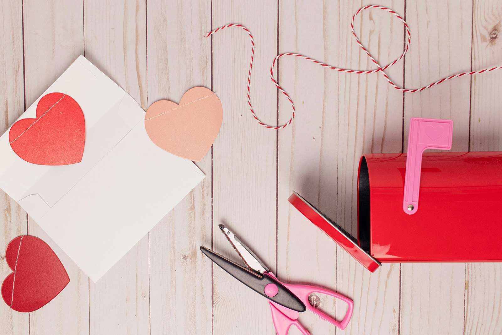 a red mailbox and several paper hearts, scissors and other craft materials